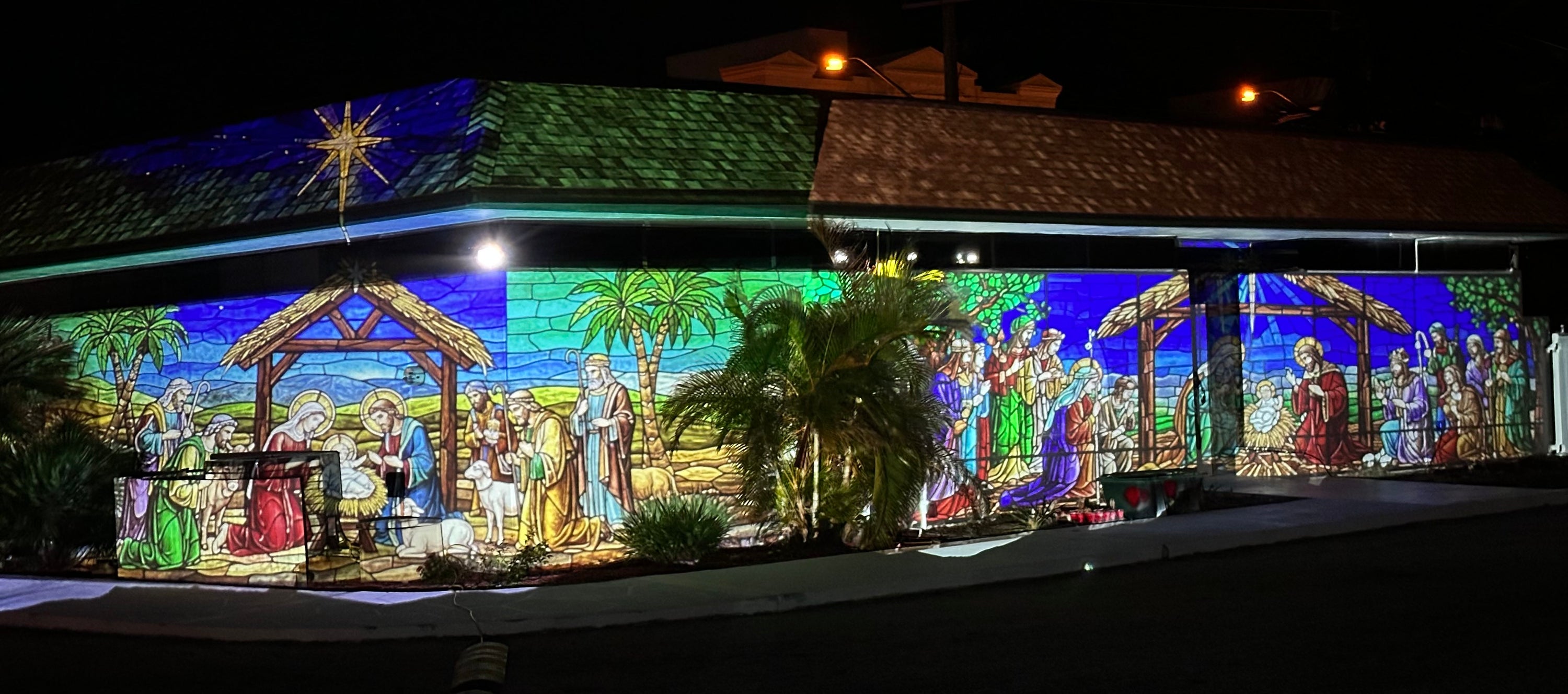 Stained glass nativity scene projection wrapping a building at night