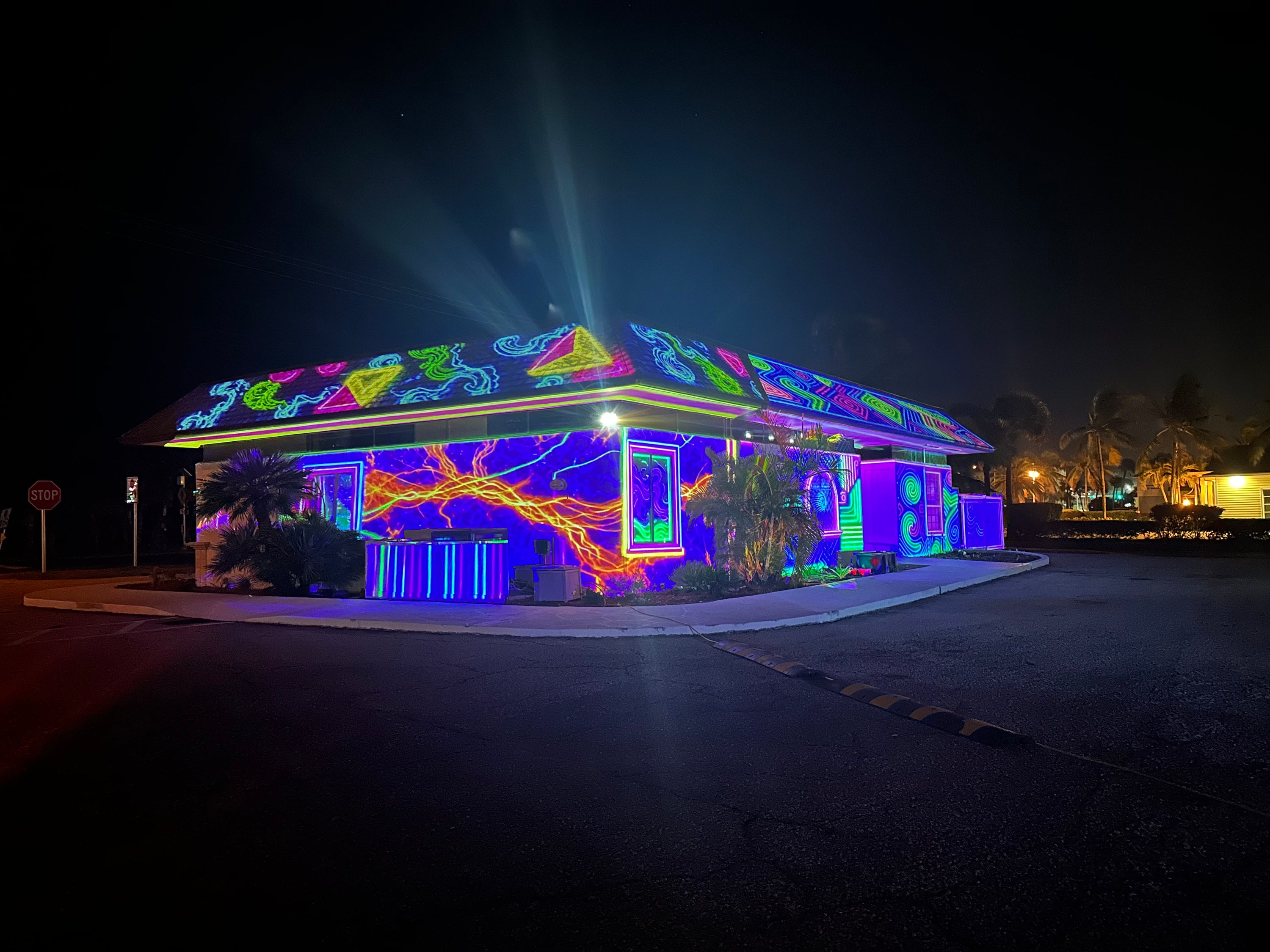 Neon laser-style projection mapping lighting up a house at night
