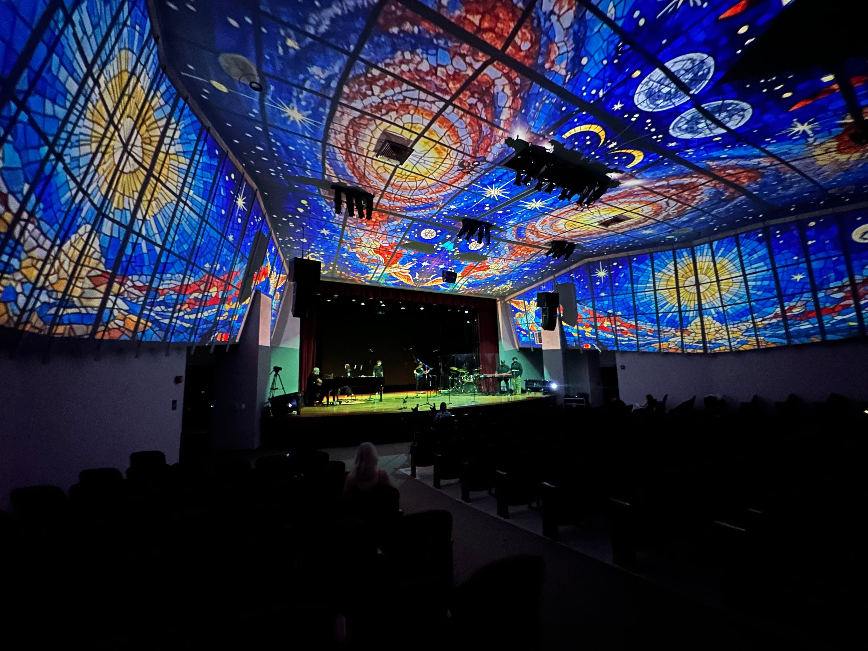 Immersive starry-night projection covering a theater ceiling and walls