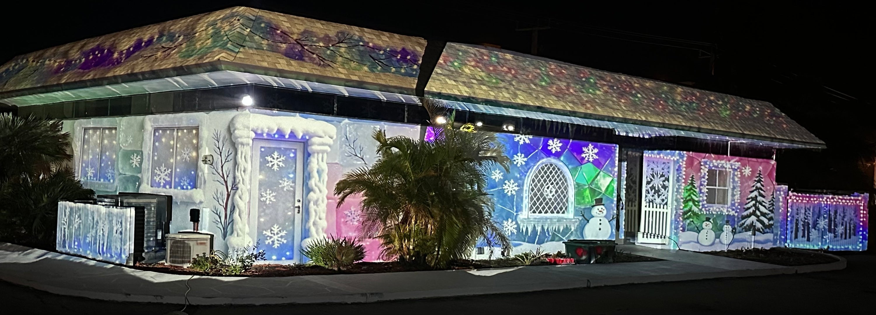 House with a winter snowman projection show at night