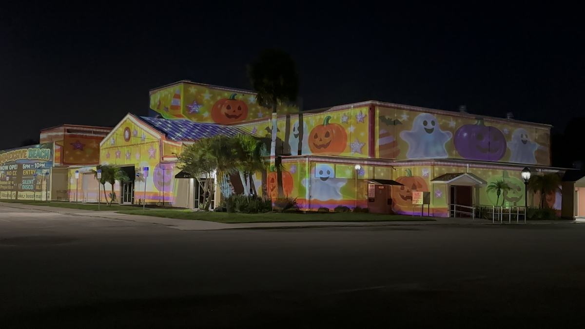 Home covered in friendly ghosts and pumpkins projection for Halloween